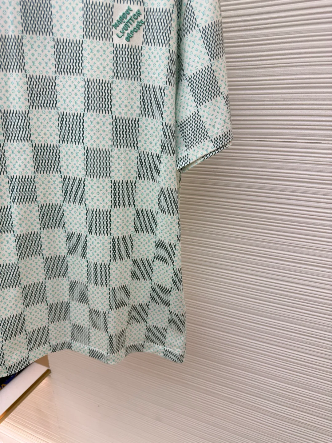 LOUIS VUITTON green checkerboard print short sleeves ●Authentic product: purchased and developed for 7300 ●Item number: 1680298-A35 ●Fabric: cotton fabric ●Technology: jacquard production ●Version: fitted version ●Weight: about 210 grams ●Size: XS-S-M-L ●Description: Made of cotton jersey fabric, chest Marque L Uuitton deposee Embroidery, simple letter pattern embellishment on the chest, the letter size spacing effect is consistent. Using linen embroidery thread combined with encrypted processing, the embroidery body has a subtle matte visual texture; the embroidery effect is three-dimensional and full. The smaller the embroidery, the more sophisticated and demanding it is. The embroidery thread is made of imported material, which is more flexible and glossy than ordinary embroidery thread; the stitches are clear and smooth, and have a three-dimensional texture effect. The whole-piece positioning quilting process is a delicate and complex technology. During the cutting process, it is necessary to ensure that the pattern or texture of each piece can perfectly match the other pieces. Through floral tailoring, the checkerboard pattern of ready-made garments appears neatly arranged. Straight round neck style, same style for men and women!
